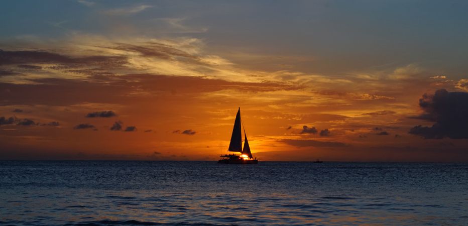Catamaran sailing into a vibrant sunset!
