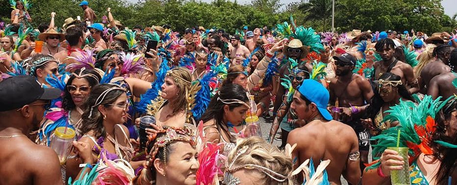 A crowd of people in colorful carnival costumes for Crop Over
