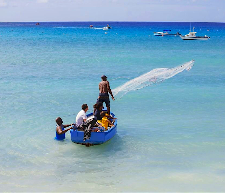 Casting the net off the coast along a Barbados beach