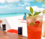 Tropical cocktail with the tranquil beach in the background