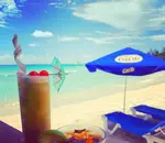 Tropical cocktail with beach lounger in the background
