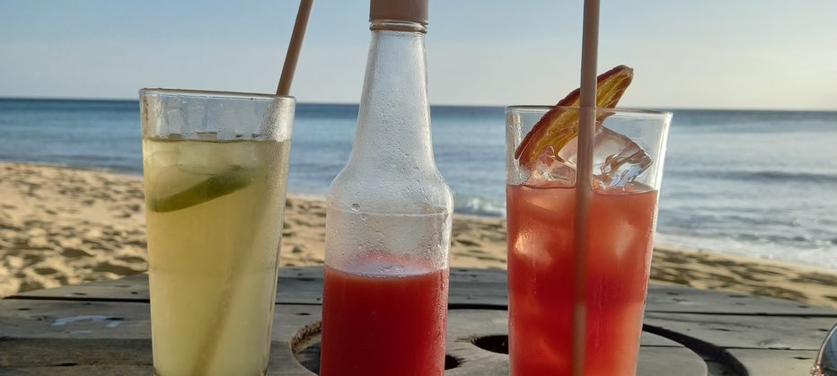 Cocktails in the foreground with beach and sea in the background