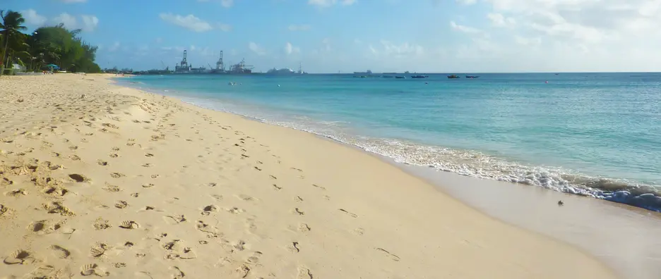 Golden sands and turquoise seas at Pile Bay with cruise port in the distance