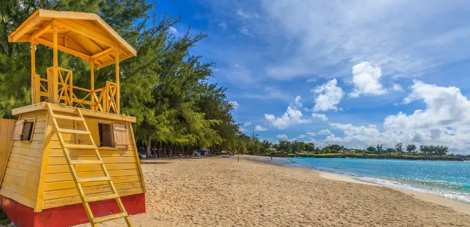 Bright yellow lifeguard station with beach in background