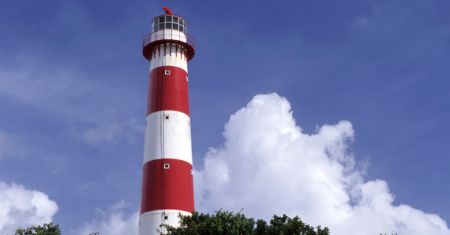 Looking up to South Point lighthouse with its distinctive red and white stripes.