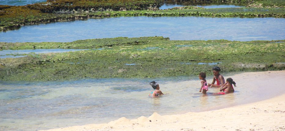 A family enjoys a relaxing soak in one of the pools at Little Bay