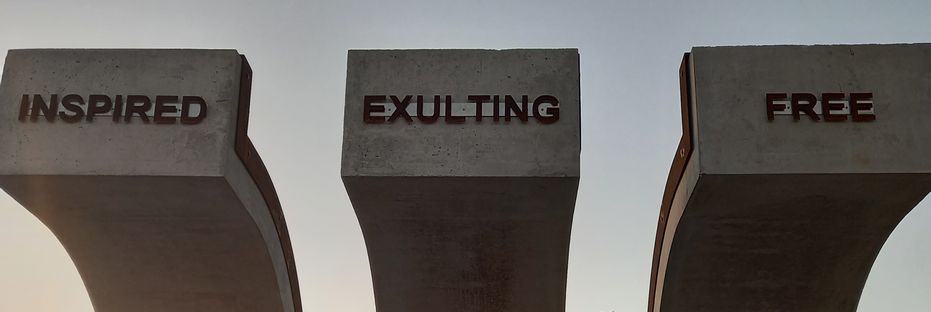 The words Inspired, Exulting, Free on the Shackles of the monument