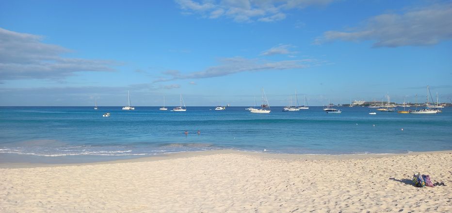 Panoramic view of Pebbles Beach with moored boats in the distance