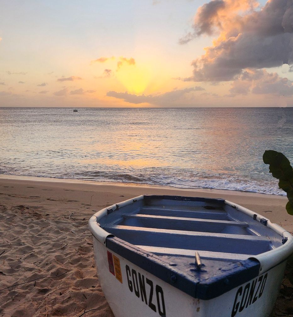 Sunset view from the beach with a boat in the foreground