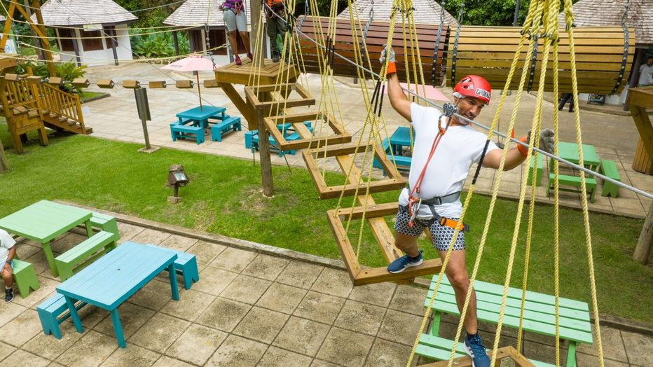 Man works his way across the ropes of the obstacle course